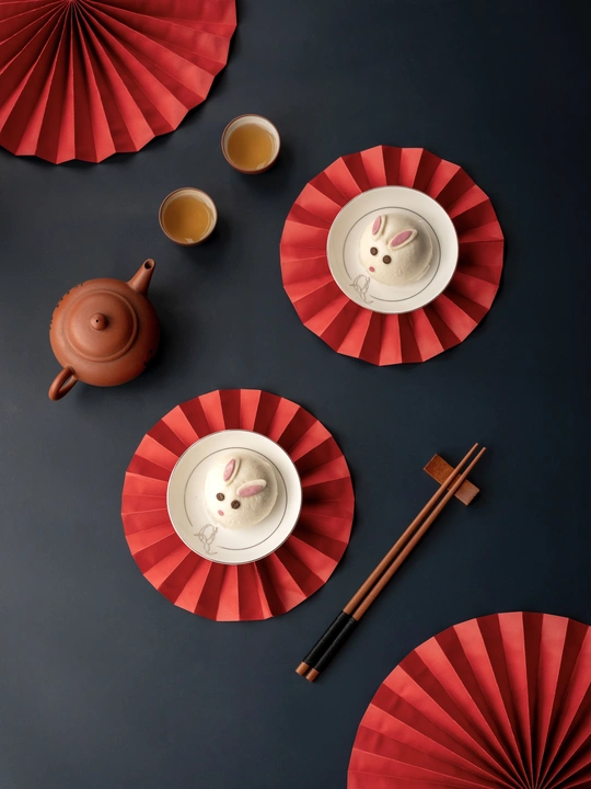 一个带有红色盘子的桌子 茶杯和茶壶。