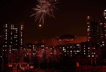 夜晚的城市 高耸的建筑物和天空中的烟花