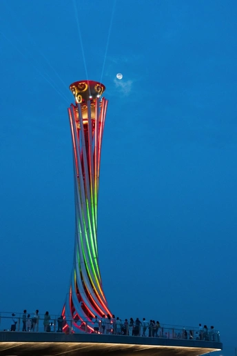 一座高塔在晚上亮了起来 人们在放风筝