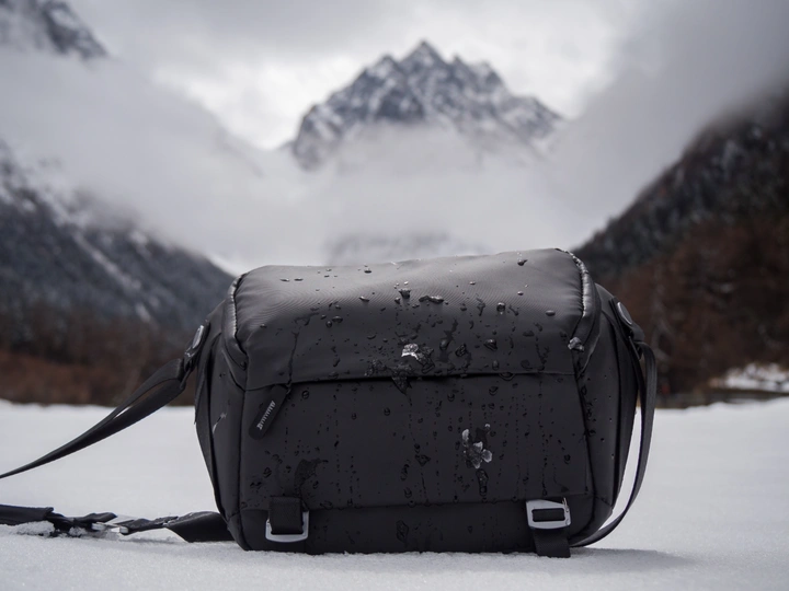 在雪中的一个黑色包裹 背景是山脉。