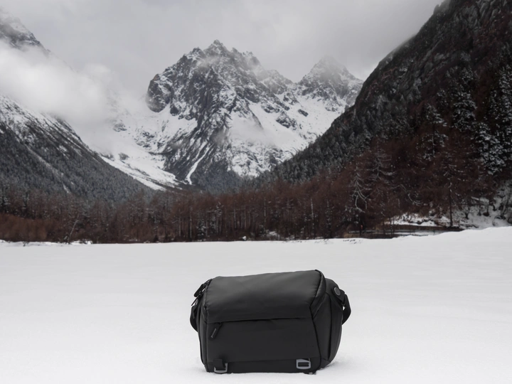 在雪中的一个黑色包裹 背景是山脉。