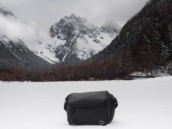 在雪中的一个黑色包裹 背景是山脉。