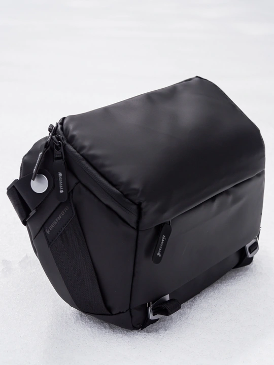 一个黑色邮差包在雪中