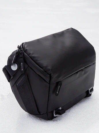 一个黑色邮差包在雪中