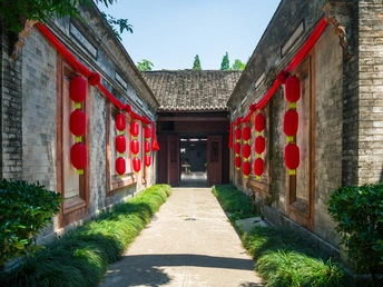 古老的中国特色房屋的庭院 门上挂着红灯笼 还有一个步行道。