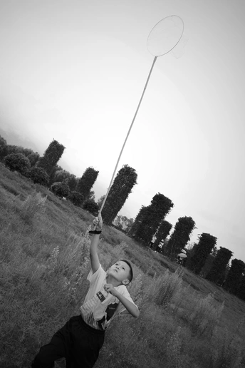 一个年轻人正在草地上和另一个人一起玩飞盘。