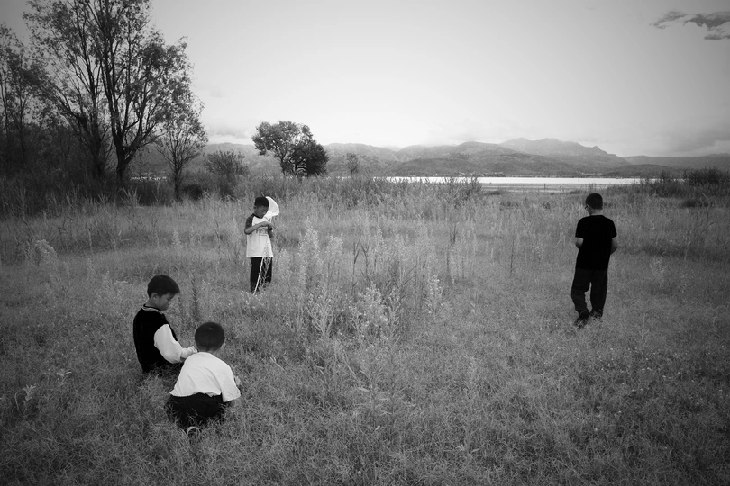 黑白照片 年轻的孩子们在田野里的大草地上玩耍。