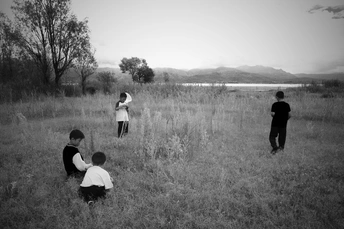 黑白照片 年轻的孩子们在田野里的大草地上玩耍。