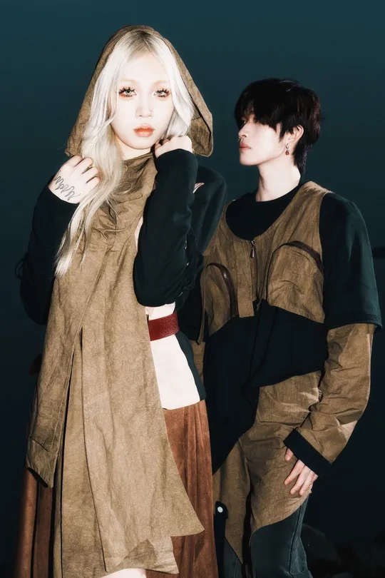 一位男性和一位女性穿着服装站在彼此旁边 背景为黑色。