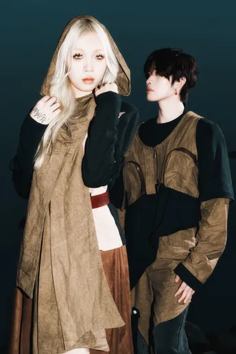 一位男性和一位女性穿着服装站在彼此旁边 背景为黑色。