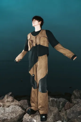 一个人穿着服装站在靠近水域的岩石上