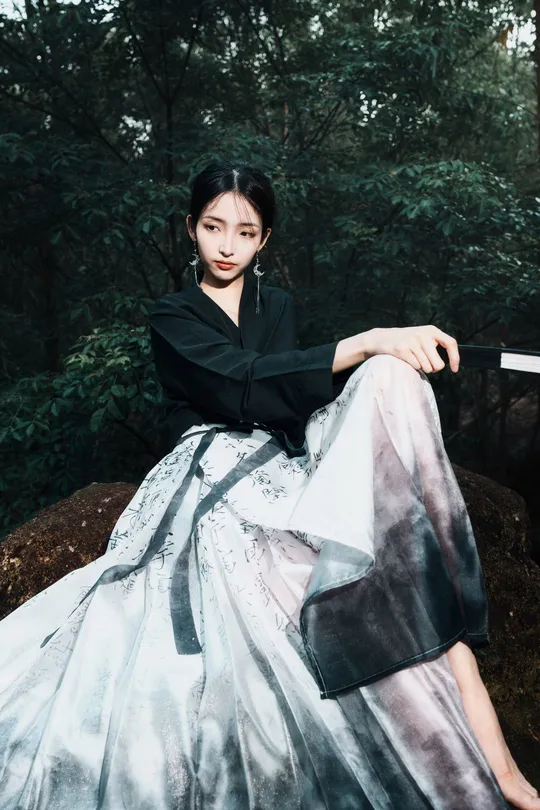 一位穿着长袍的女孩坐在树林里