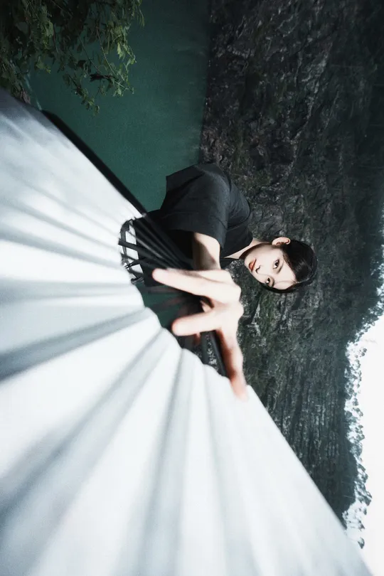 一位穿着白色连衣裙的女人靠近一棵树。