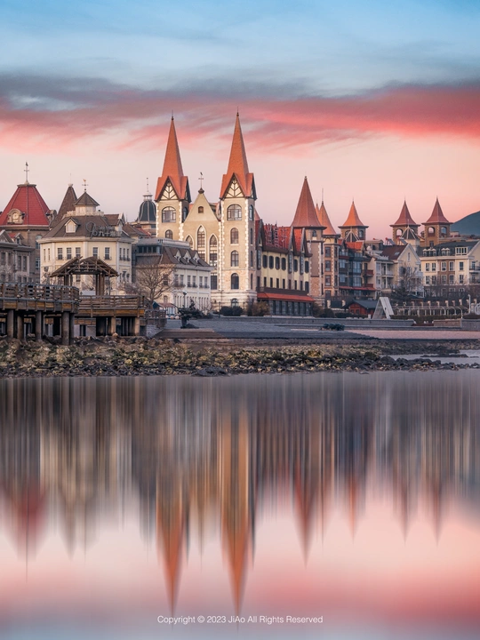 城市上空美丽的日落 前景中有建筑和湖泊