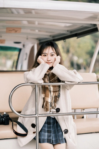 一位穿着白大褂的年轻女子站在一艘船上