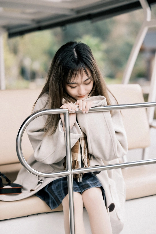 一位年轻女子坐在船上 倚靠在栏杆上