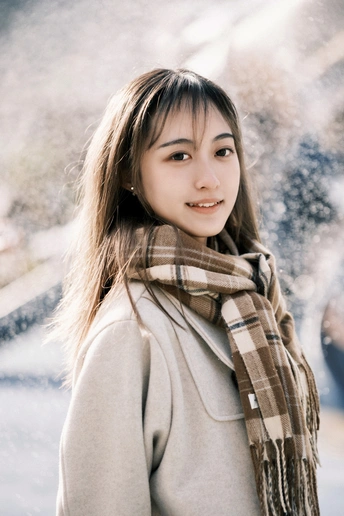 一位穿着外套和围巾的年轻女子在冬天的雪中行走的肖像