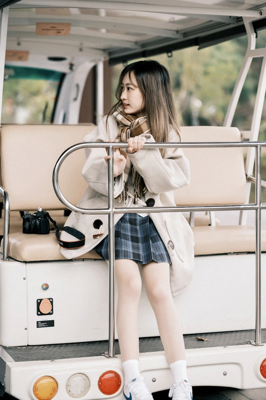 一位穿着白大褂的年轻女子坐在船上