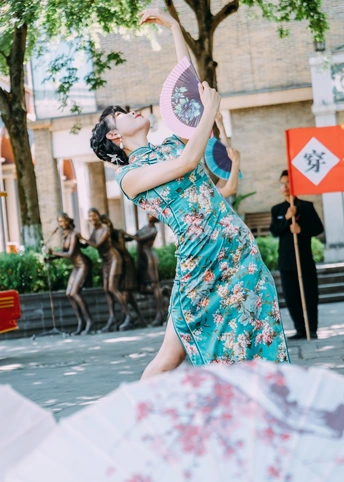 一位穿蓝色连衣裙的女士正在街上跳舞 手里拿着一把伞。