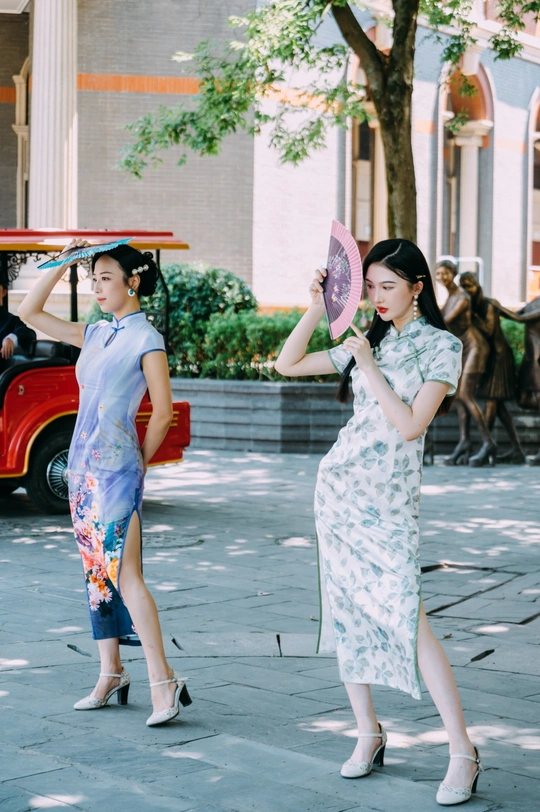 一位穿着传统裙子的年轻女子拿着雨伞