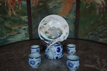 一张桌子 上面放着蓝色的花瓶和白色的小盘子