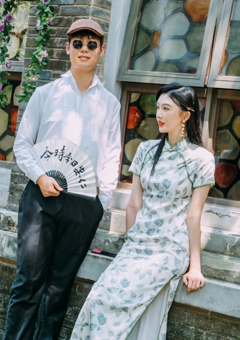 一个年轻男子和穿着连衣裙的年轻女子站在外面。