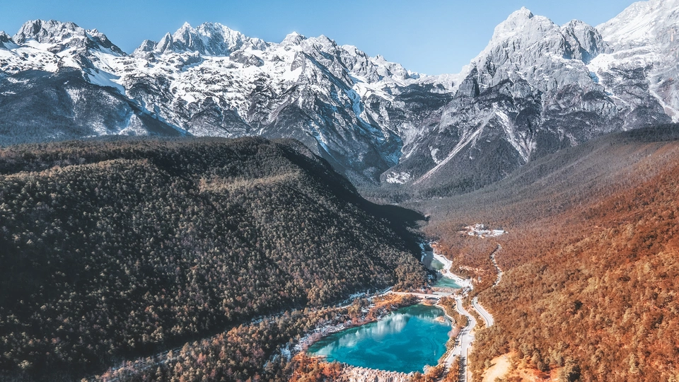 一个被积雪覆盖的山谷 周围环绕着一条蓝色的河流。