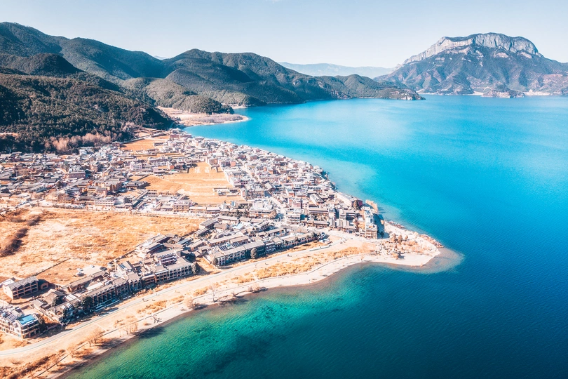 背景中有一座城市和山脉的大型蓝色水域