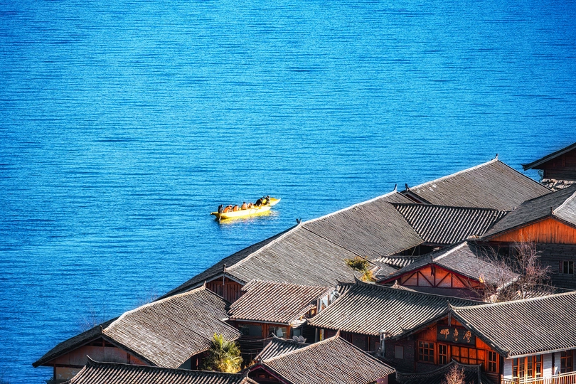 一片蓝色的水域 中间有船 周围有小型建筑。