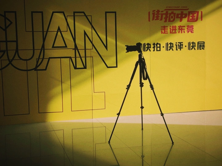 在墙前的一架三脚架相机 有光和阴影。