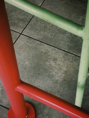 一把红色的椅子 旁边有一根绿色的杆子。