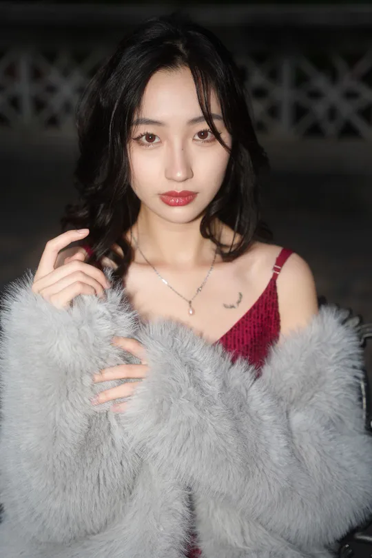 一位穿着由Person品牌提供的红色和灰色皮草大衣的模特