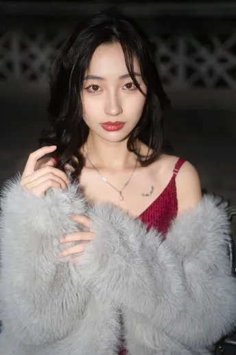 一位穿着由Person品牌提供的红色和灰色皮草大衣的模特