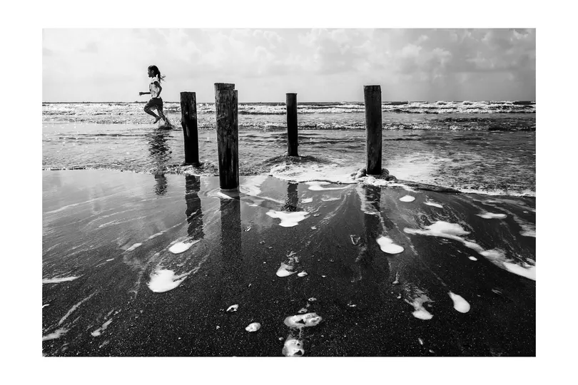 黑白照片上有一男一女在码头上 水中有柱子。