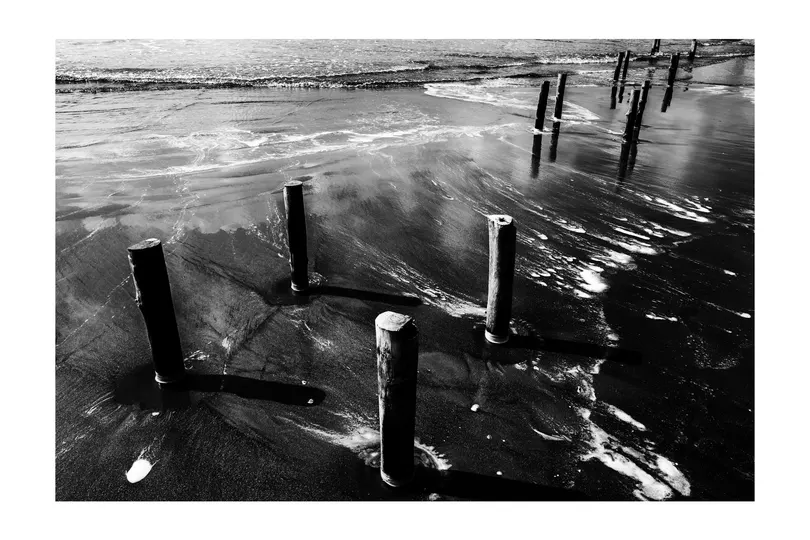 低潮时海滩上的黑白相间的柱子