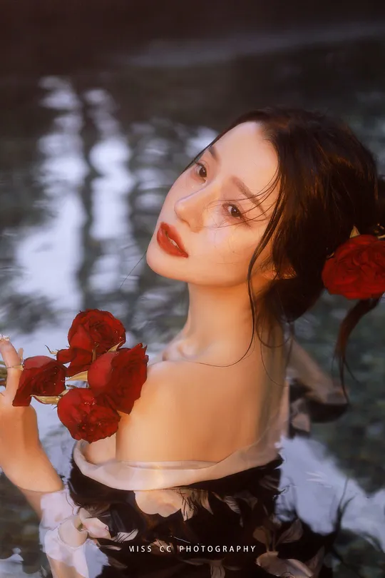 一位穿着连衣裙的女人 holding a red rose in water 画了一幅她的肖像。