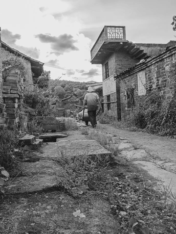 一个黑白照片 一个男子正在搬运一座旧建筑。