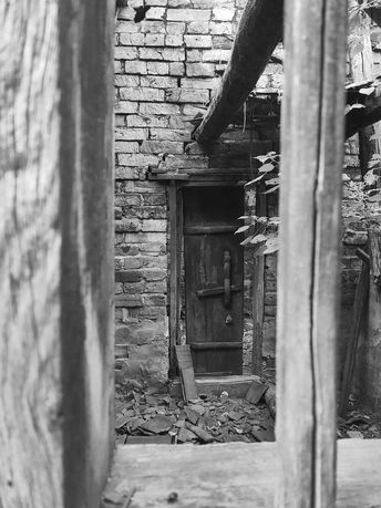 废弃房屋中的一扇木门黑白照片
