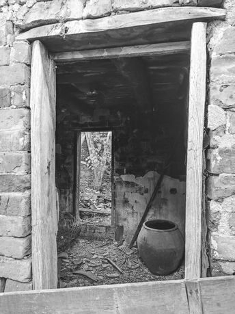 一座老石头房子窗口里的黑白色花瓶