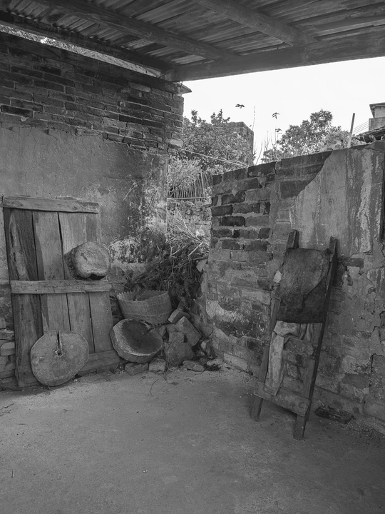 一张黑白的老房子照片 墙上放着一些花盆