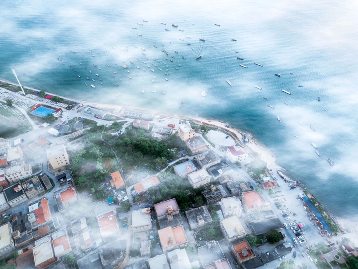 海洋中央的岛屿上的城镇或城市的空中视角 天空中有水和云。