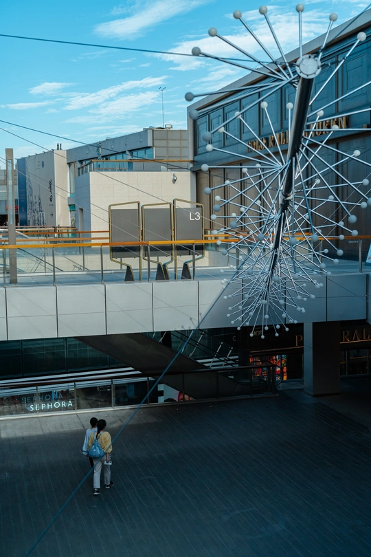 一个人和一个孩子站在一座城市的大型雕塑前