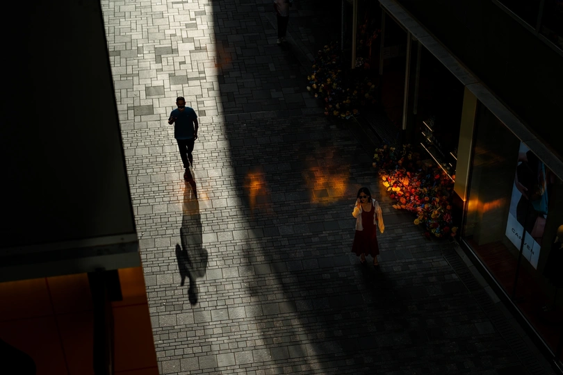 一男一女晚上走在街上 建筑物上的灯光留下了阴影