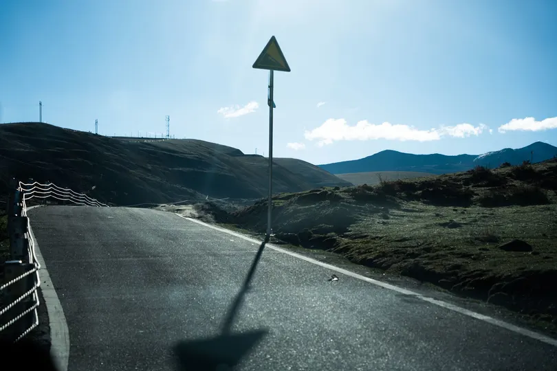 背景是山丘和山脉的道路上 公路标志的阴影。