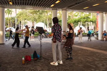 有些人站在一栋建筑下 一支乐队正在弹吉他。