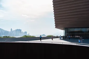 人们穿过一座桥 背景是高楼大厦。