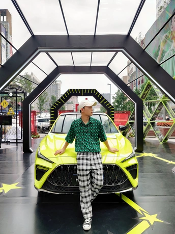 一个男人站在一辆黄色汽车旁边