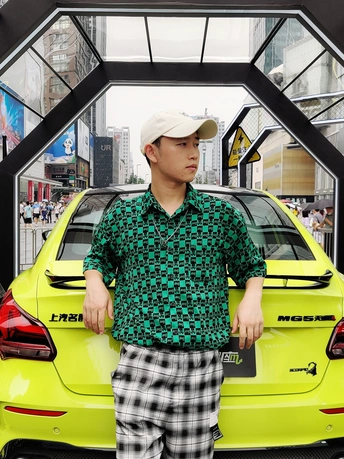 一个男人站在一辆黄色汽车旁边