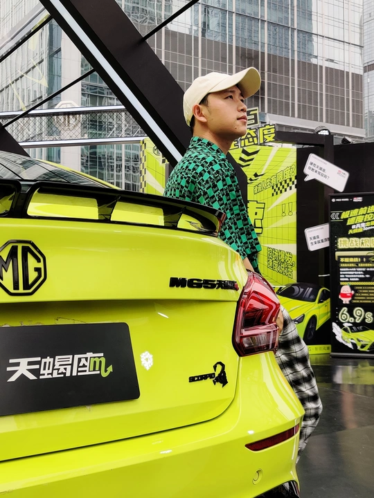 一个男人站在一辆黄色汽车旁边