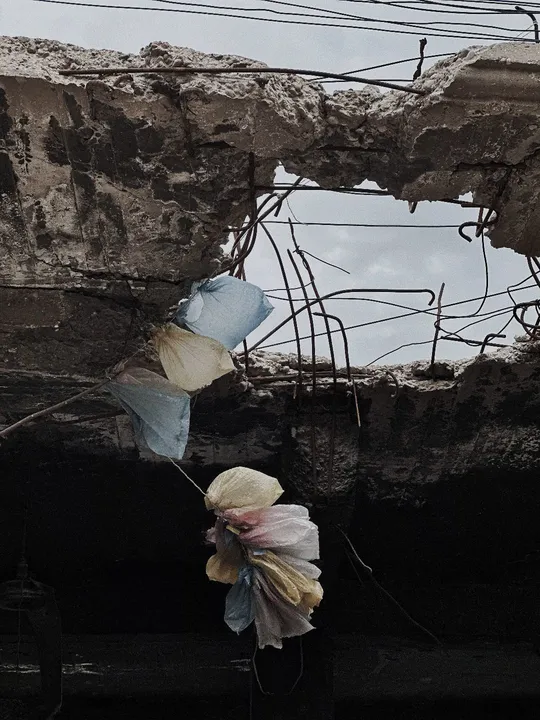 墙上的一个洞 里面挂着塑料袋和花。